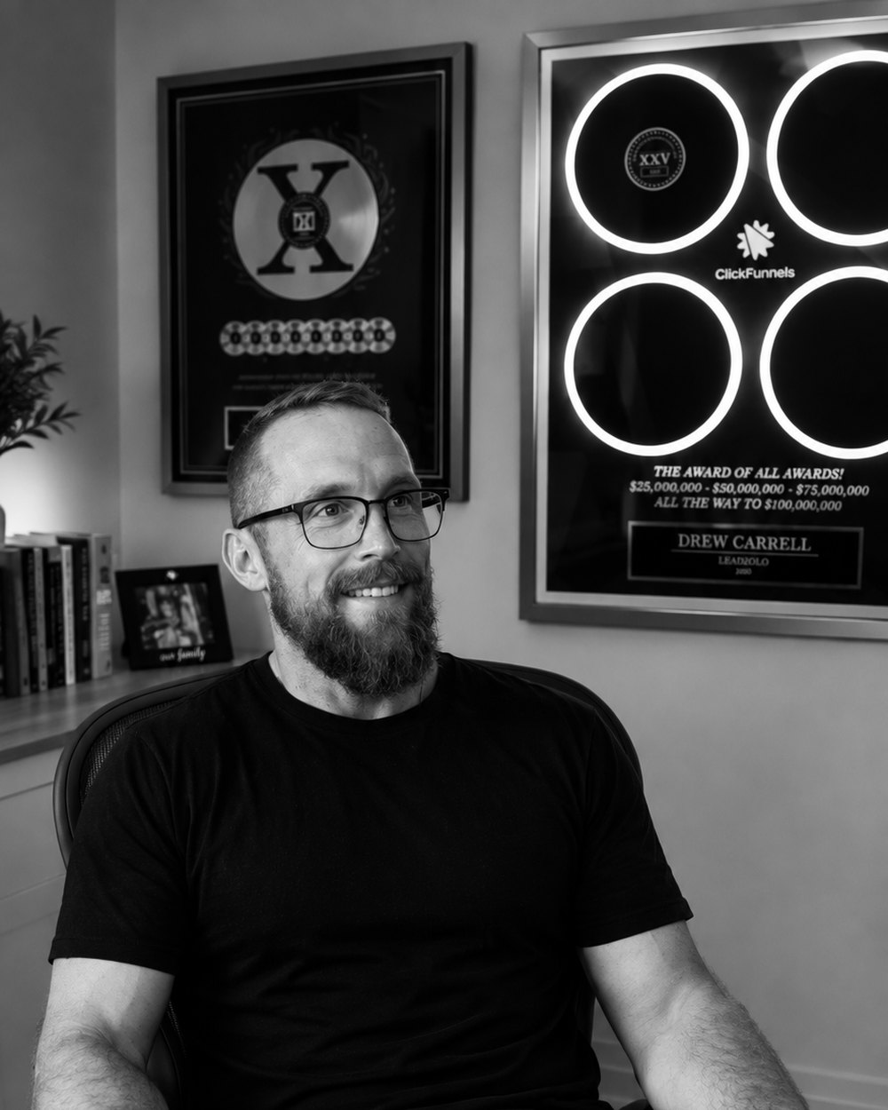 Drew Carrell in his office, ClickFunnels awards on the wall behind him