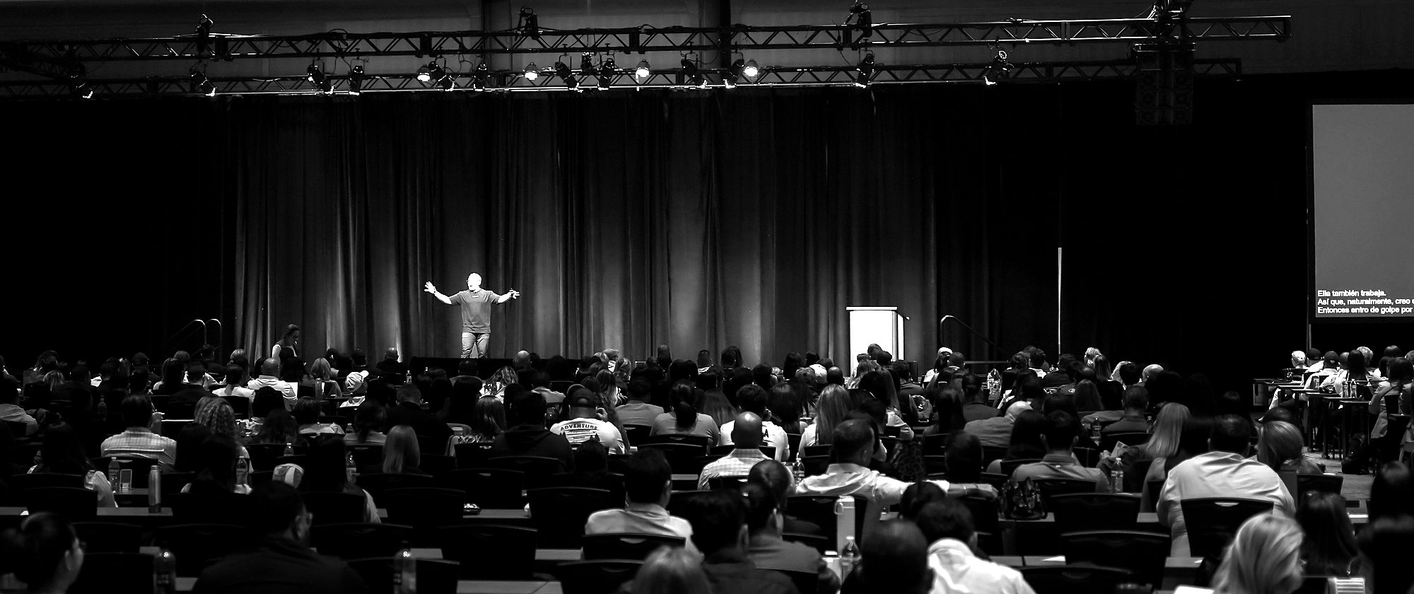 Drew Carrell on stage in front of a full conference hall